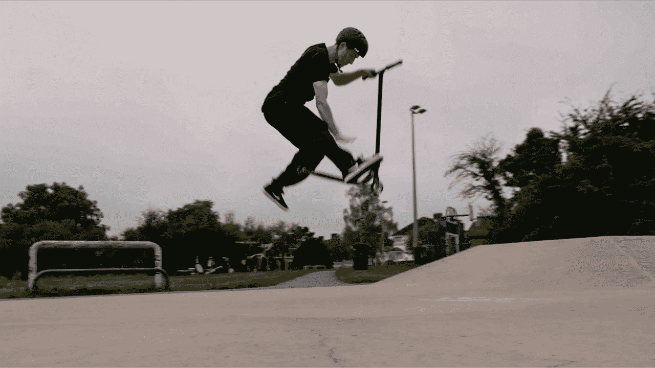 Sebastian performing a scooter trick in a skate park