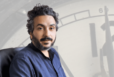 Nima Khalighinejad against the background of a clock. Featured image for the video "How do we decide when to act?"